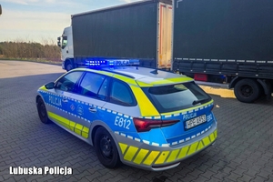 radiowóz stoi obok ciężarówki