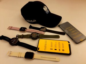 zabezpieczone zegarki, telefony oraz policyjna czapka