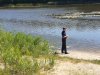 policjant nad brzegiem jeziora w trakcie letniej kontroli