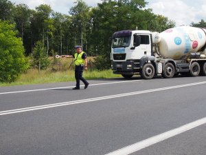 policjant drogówki zatrzymujący do kontroli pojazd ciężarowy